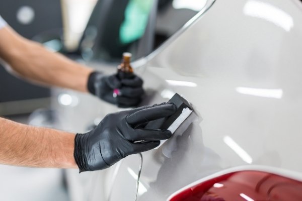 Staff applying ceramic coating to a car